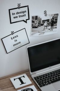 Kaboompics - Vertical Creative Desk Scene with “In Design We Trust” and “Less Is More” Art Prints