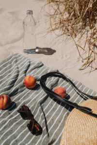 Kaboompics - Clear Water Bottle, Peaches and Straw Bag on a Beach Towel