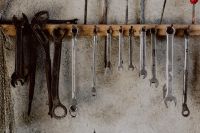 Kaboompics - Rusty Antique Wrenches and Silver Spanners on a Wooden Rail