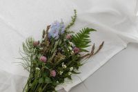 Kaboompics - Wildflower Bouquet with Ferns and Blue Blossoms on White Fabric