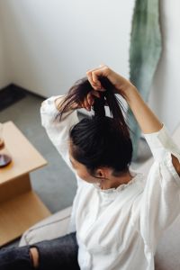 Kaboompics - Woman Gathering Her Hair in Soft Window Light