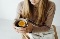 Kaboompics - Woman Holding a Cup of Orange Tea