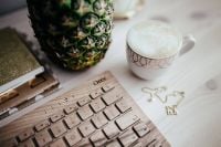 Kaboompics - Wooden Keyboard Workspace with Pineapple and Coffee