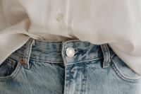 Kaboompics - White Silk Blouse Tucked into Two-Tone Light Blue Jeans, Close-Up Outfit Detail
