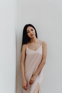 Kaboompics - Relaxed Woman in Pale Slip Dress Standing against White Wall