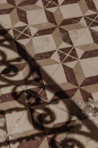 Kaboompics - Brown and Cream Star Tile Floor with Sunlight and Shadow