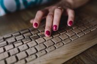 Kaboompics - Closeup of female hands typing text on a wireless wooden keyboard