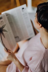 Kaboompics - A woman with short dark hair reads a newspaper