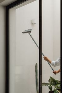 Kaboompics - Woman Washing a Floor-to-Ceiling Window