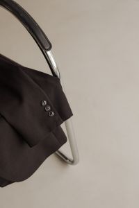 Kaboompics - Black Blazer Sleeve and Chrome Chair Arm Close-Up