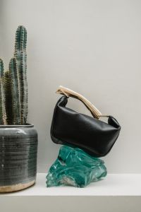 Kaboompics - Black Leather Handbag on Turquoise Sculptural Accent
