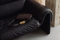 Kaboompics - Woven Brown Handbag on a Black Leather Sofa