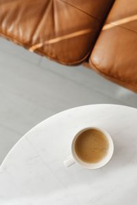Kaboompics - Top-Down Coffee Cup on White Marble by a Tan Leather Sofa for Home Decor Editorials