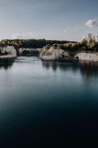 Kaboompics - Forested Limestone Cliffs Above Blue Quarry Water
