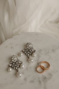 Kaboompics - Pearl Drop Earrings and Gold Wedding Rings on Marble