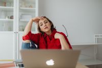 Kaboompics - Tired Woman Reclining beside Laptop, Hand on Head and Glasses in Other Hand