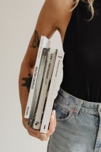 Kaboompics - Close-Up of Books Tucked Under a Woman's Arm