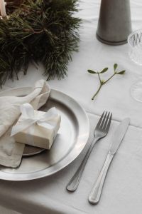 Kaboompics - Close Up Wrapped Gift on Silver Plate with White Napkin, Fork and Knife