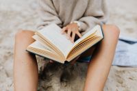 Close-Up Beach Reading, Open Book on a Woman’s Lap