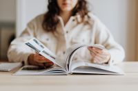 Kaboompics - Woman Holding Open Book at Desk