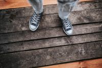 Kaboompics - Woman in black Converse sneakers and ripped jeans