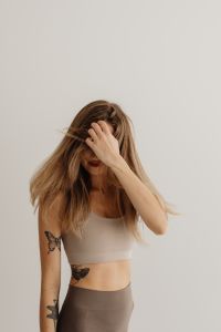 Kaboompics - Woman Touching Her Hair Against a Neutral Wall