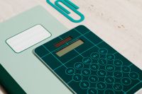 Kaboompics - Close-Up Teal Calculator on a Green Notebook for Math Homework and Education Design