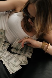 Kaboompics - Woman Picking Up Cash From a Pile of Dollar Bills