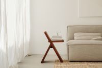 Kaboompics - Modern Living Room with Wooden Stool, Books, Water Glass and Gray Sofa