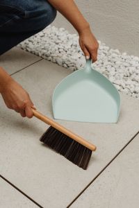 Kaboompics - Woman Sweeping a Tiled Floor with a Dustpan