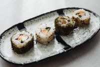 Kaboompics - Four Assorted Sushi Rolls on a Speckled Oval Ceramic Plate
