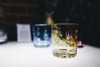 Kaboompics - Yellow Crystal Tumbler with Colorful Glasses Behind