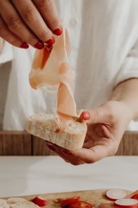 Kaboompics - Woman Draping Prosciutto over a Bread Slice