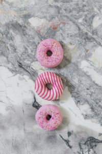 Colorful Donuts On Marble With Laptop And Glass Plate