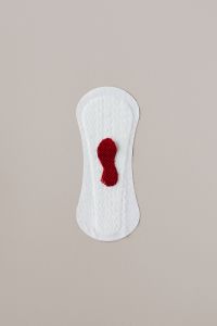 Kaboompics - White Sanitary Pad with Dark Red Fabric Accent, Portrait Product Photo