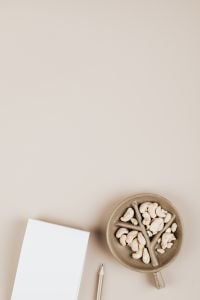 Kaboompics - Cashews in Ceramic Dish with Pencil and Notebook