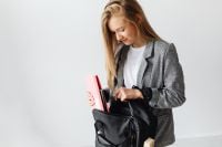 Kaboompics - Female Student Packing Books into a Black School Backpack