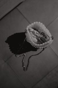 Kaboompics - Black and White Pearl Beaded Evening Bag Casting a Long Shadow on Tile