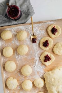 Kaboompics - Cherry Jam and Filled Pączki Dough Beside a Lace Napkin