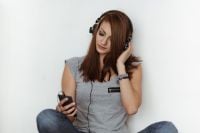 Kaboompics - Beautiful young woman in headphones listening to music