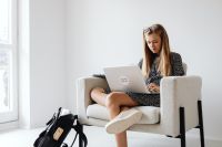 Kaboompics - Teenage Student Using Laptop While Sitting in Armchair