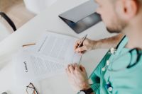Kaboompics - Overhead View of Doctor Completing Paperwork
