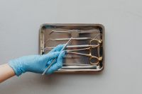 Kaboompics - Gloved Hand Selecting Dental Mirror From Instrument Tray