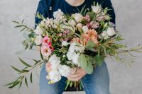 Kaboompics - Man Holding a Pastel Bouquet against a Plain White Studio Background