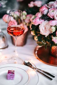 Kaboompics - Close-Up Rose Wine Glass beside a Pink Floral Centerpiece
