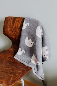 Kaboompics - Grey Baby Blanket with White Animal Print on Wooden Chair