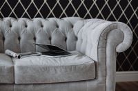 Kaboompics - Silver laptop and an iPhone on a grey sofa