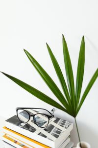 Kaboompics - Eyeglasses on an Illustrated Book beside Palm Leaves