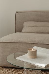 Kaboompics - Minimalist Sofa Interior with Candle, Open Book and Soft Neutral Textures