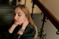 Kaboompics - Close-Up Urban Fashion Portrait Featuring Gold Wristwatch and Glossy Black Jacket